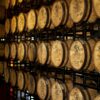 A wall of barrels in a warehouse filled with wood.